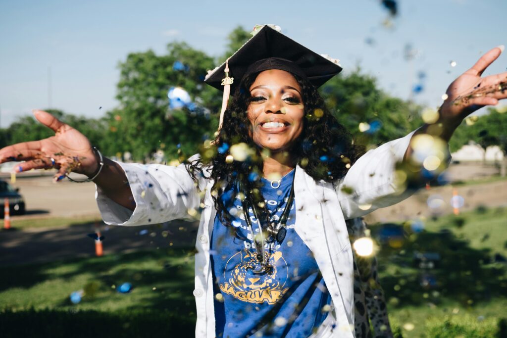 pexels-photo-1139317-1139317 African American woman celebrating graduation with confetti outdoors, filled with happiness and success.