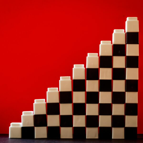 Checkered pattern blocks arranged in a stair formation against a vivid red backdrop.