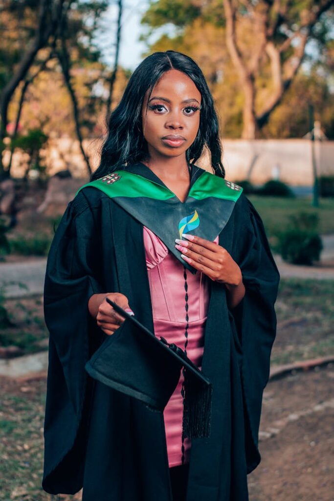 pexels-photo-29215439 Young woman in graduation attire celebrating her achievements outdoors.