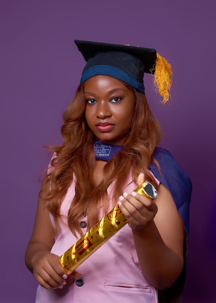 Photo by Audu Samson Portrait of a Nigerian graduate holding a diploma, symbolizing academic success.