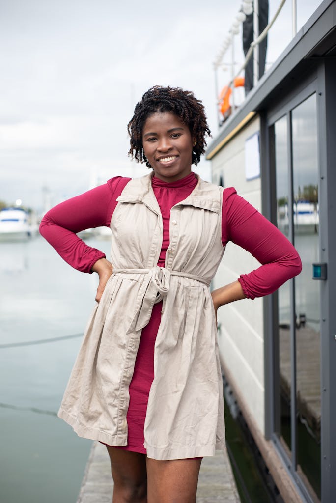 Photo by Kampus Production Portrait of a smiling woman in Portugal, posing confidently by the waterfront.