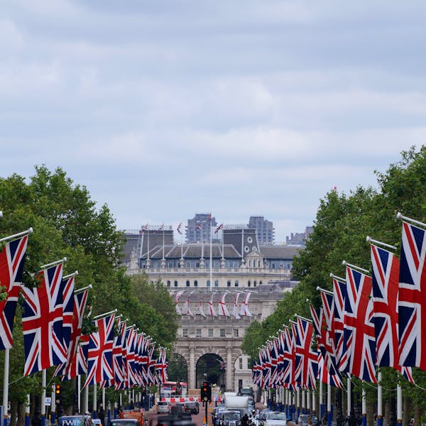 Union Jack flags line The Mall in London leading up to Admiralty Arch, showcasing British pride.