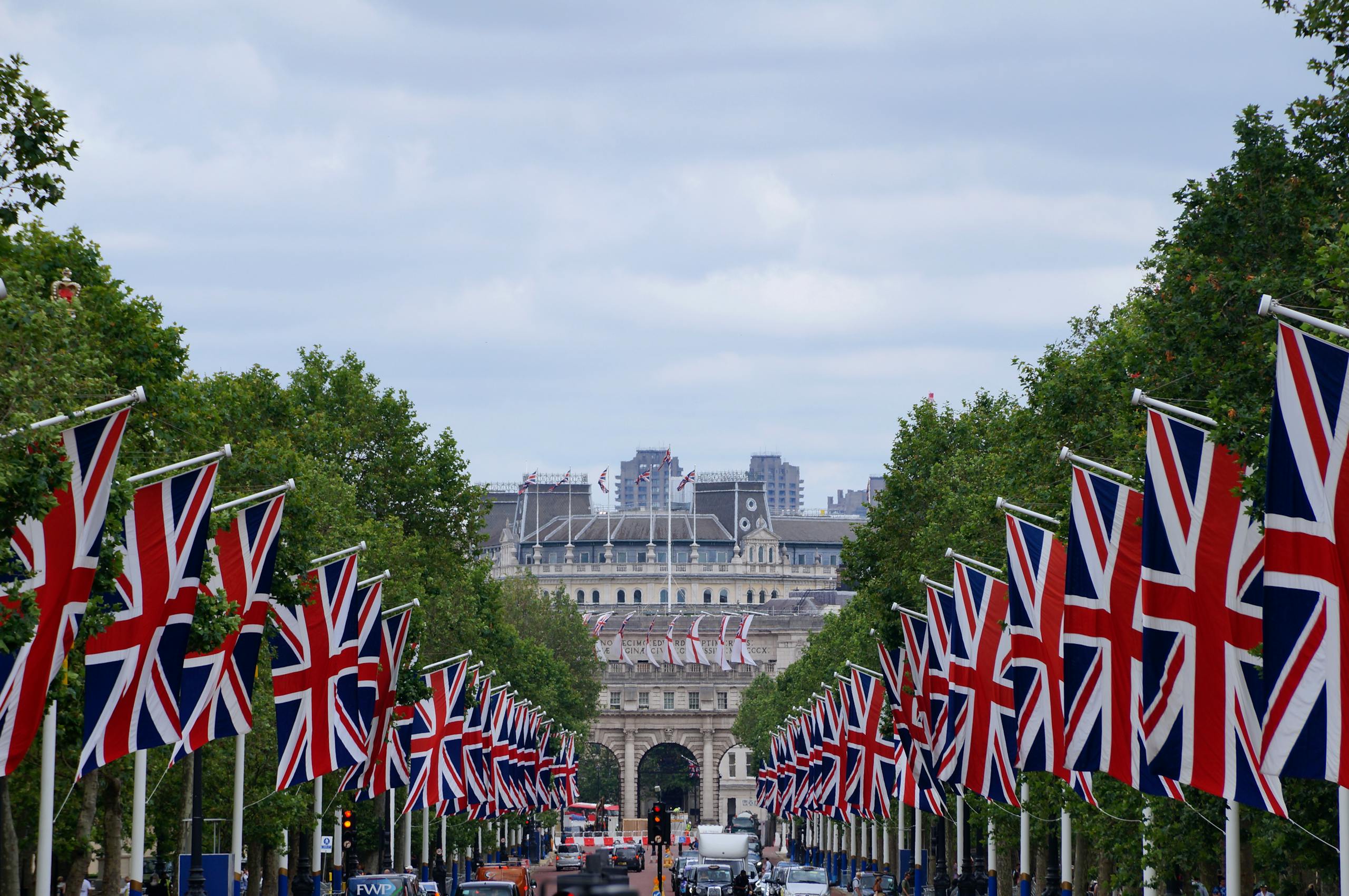 Union Jack flags line The Mall in London leading up to Admiralty Arch, showcasing British pride.